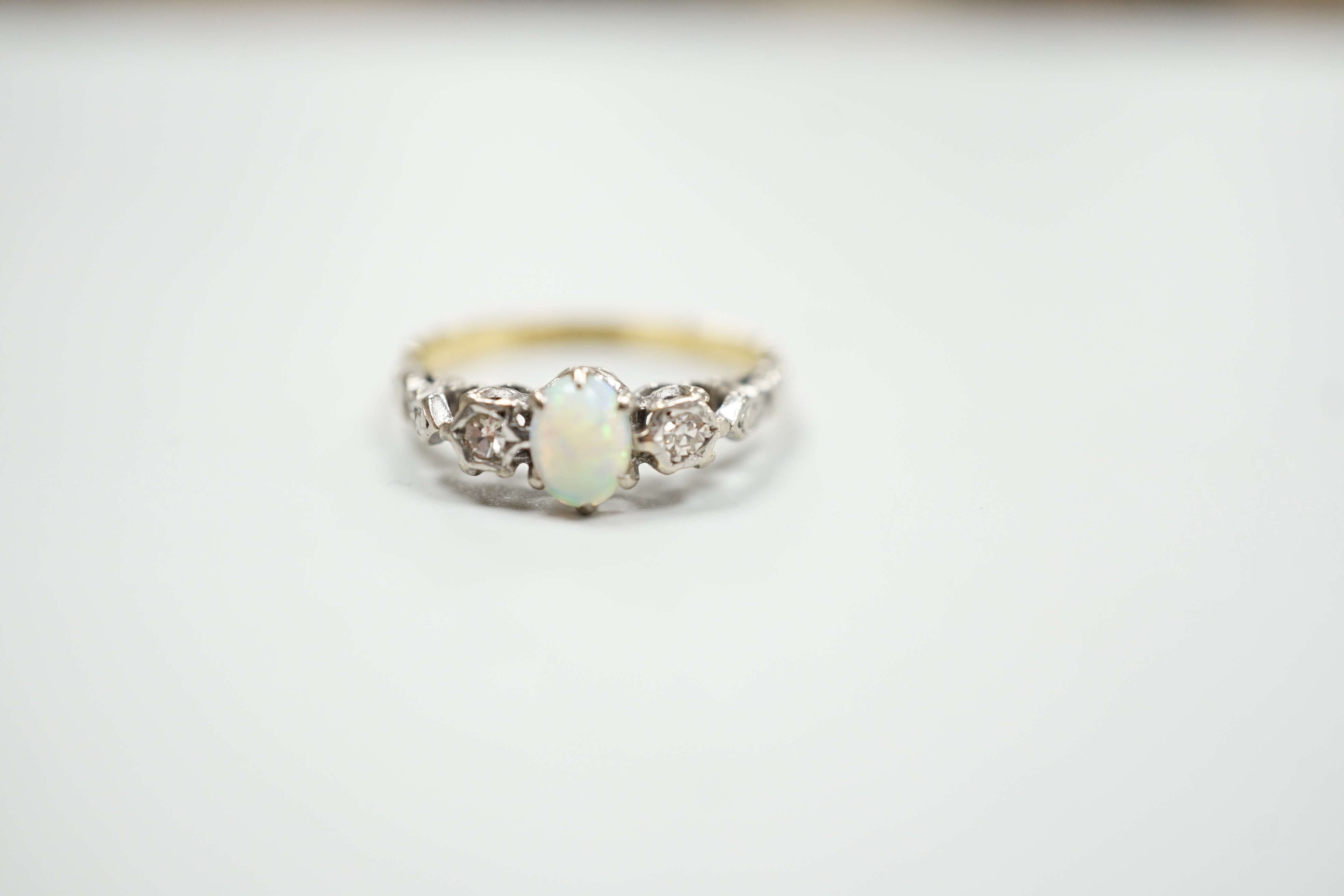 An 18ct and plat, single stone cabochon white opal and two stone diamond set ring, size L/M, gross weight 2.8 grams.